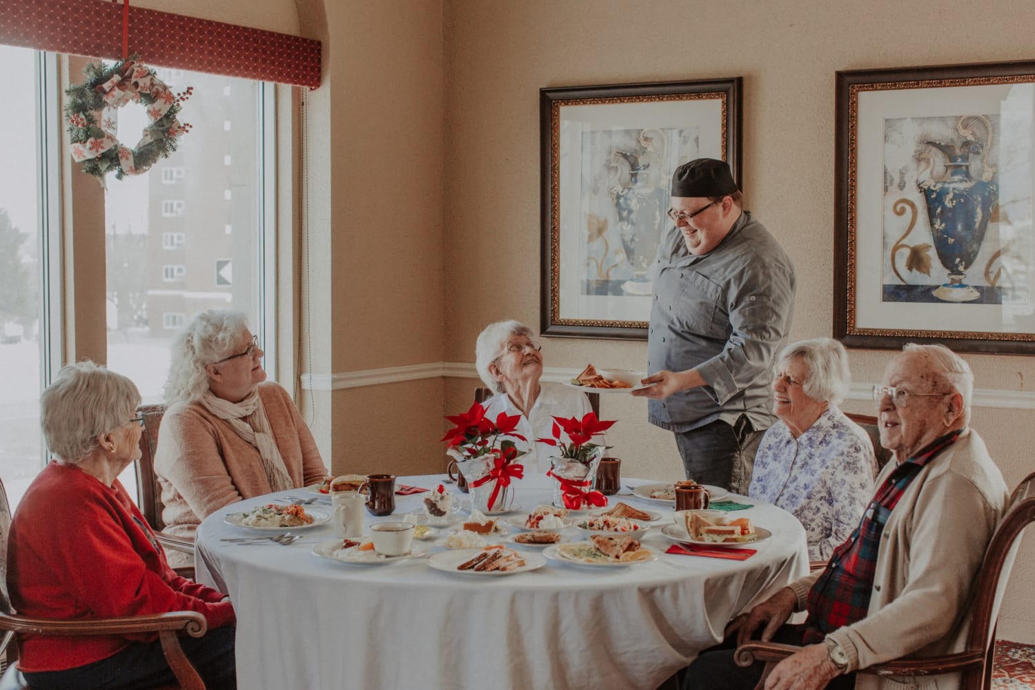 Resident dining together at a large round table at The Whitcomb Senior Living Tower in St. Joseph, Michigan