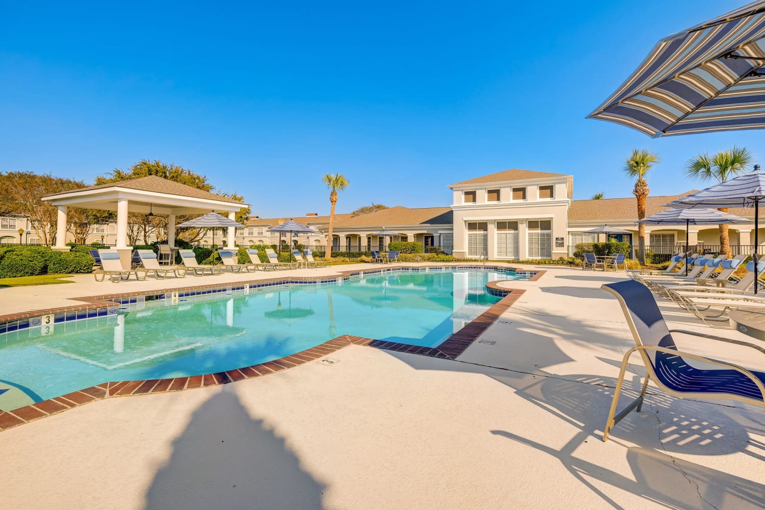 Pool and patio area at Chateau des Lions Apartment Homes in Lafayette, Louisiana