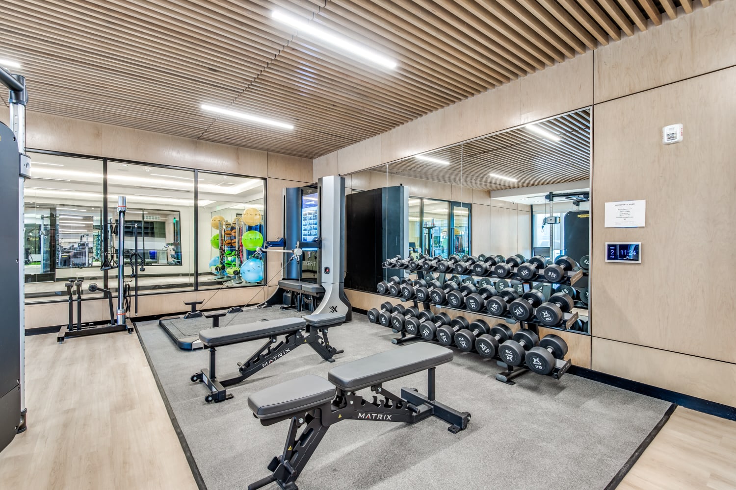 Fitness center with benches and free weights at Mezzo Apartments in Aubrey, Texas