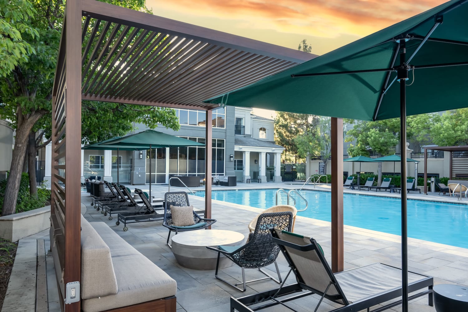 Poolside lounge chairs with sun umbrella at The Carlyle in Santa Clara, California