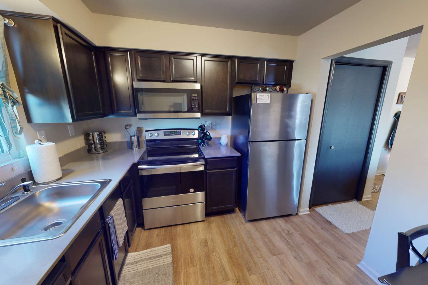 Apartment kitchen with stainless-steel appliances at The Quarters at East Lansing in East Lansing, Michigan