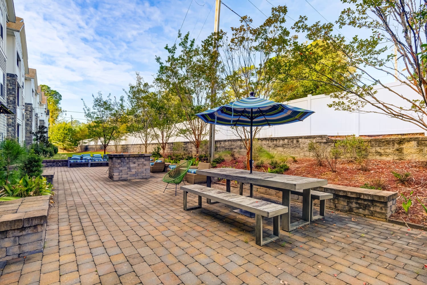 Resident patio with a picnic table and umbrella at Creekside at Greenlawn Apartment Homes in Columbia, South Carolina