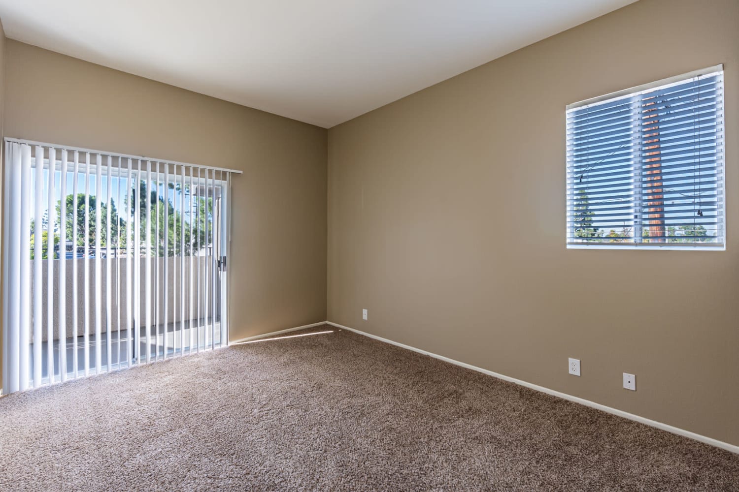 Bedroom with sliding glass door to private patio at Seapointe Villas in Costa Mesa, California