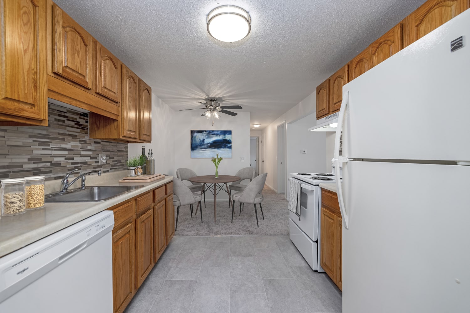Kitchen with white appliances at Perinton Manor Apartments in Fairport, New York