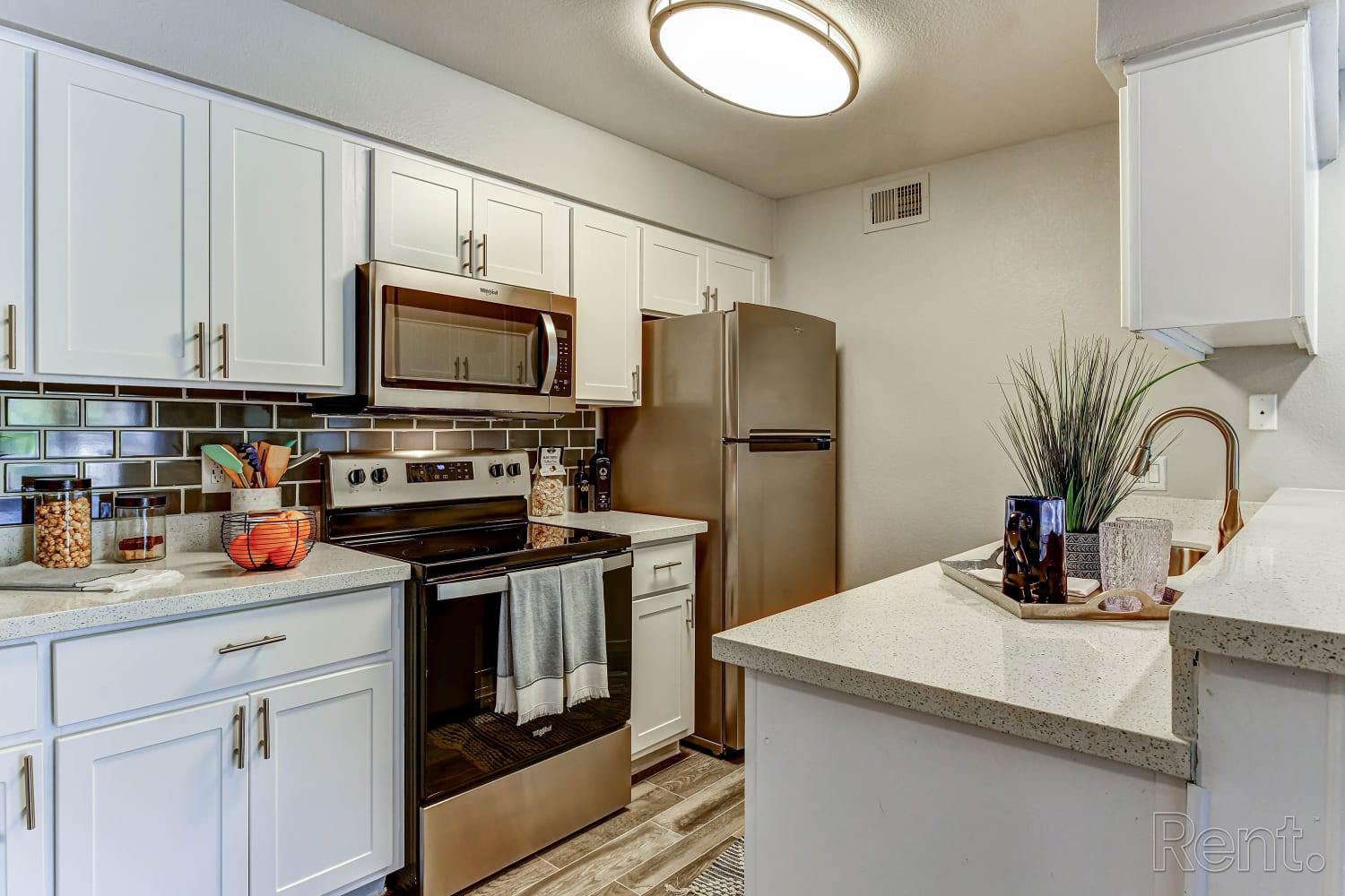White cupboards and stainless-steel appliances in an apartment kitchen at Station 21 Apartments in Mesa, Arizona