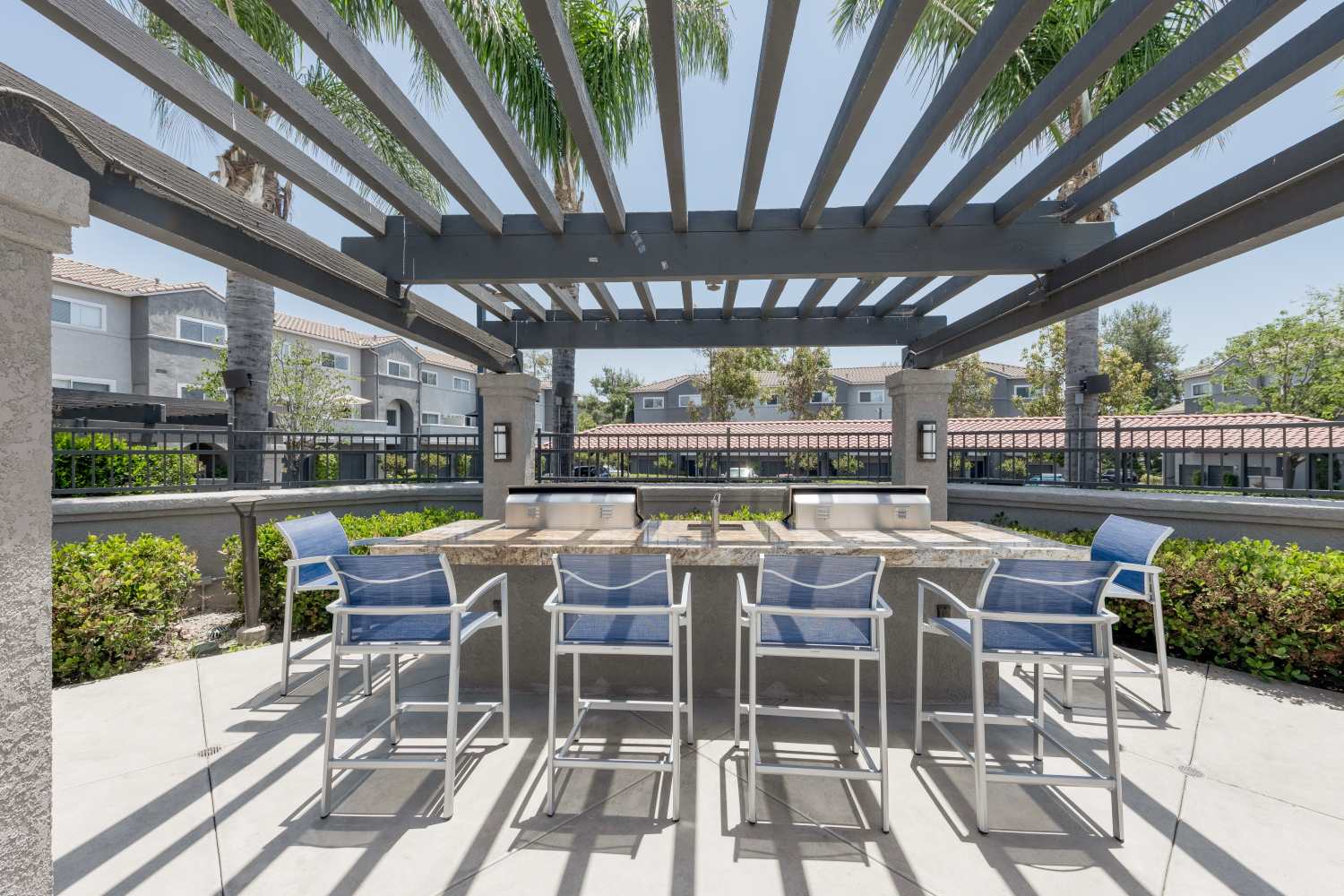 Seats by the outdoor grill at Madrid Apartments in Mission Viejo, California