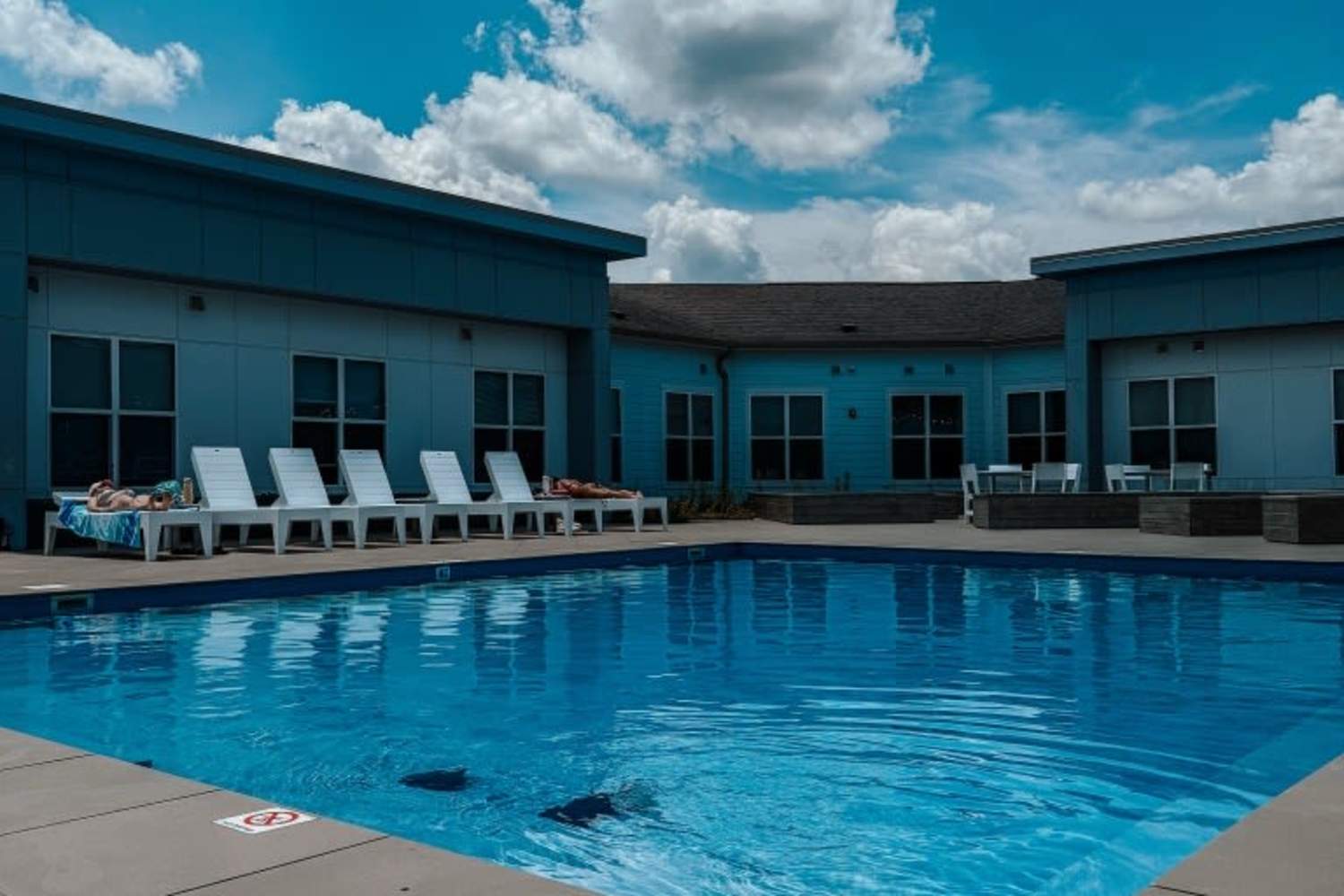 Exterior and community pool at The Quarters Bloomington in Bloomington, Indiana