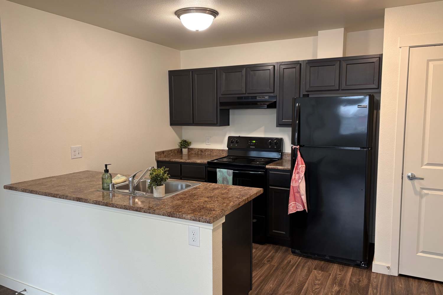 Kitchen with refrigerator and other appliances at K West Apartments in Vancouver, Washington