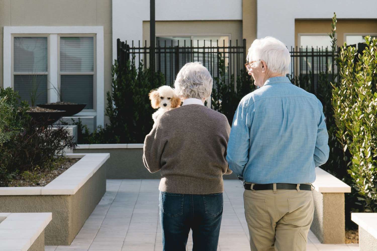 Elder couple holding their dog in the neighborhood at Acapella in Las Vegas, Nevada