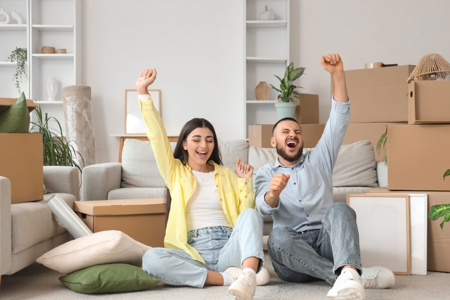 happy couple sitting on floor with moving boxes Demmon Partners Corporate in Sacramento, California