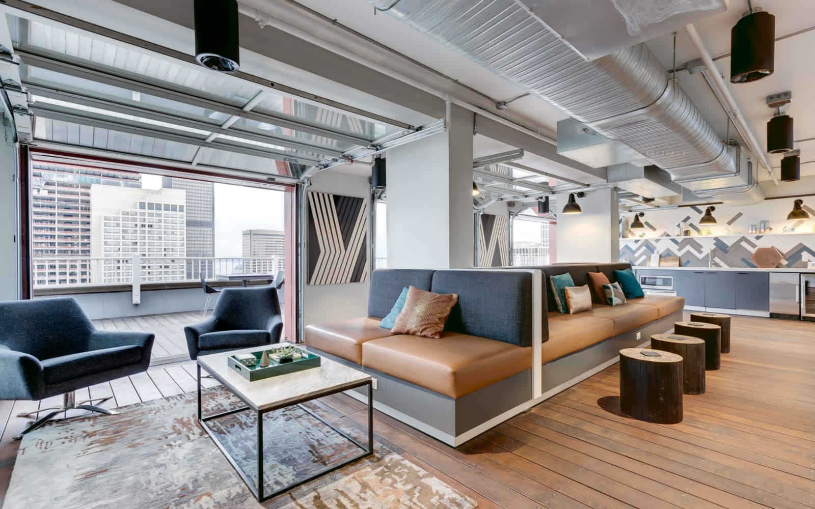 Indoor lounge area with roll up garage doors to rooftop deck at M Street in Seattle, Washington