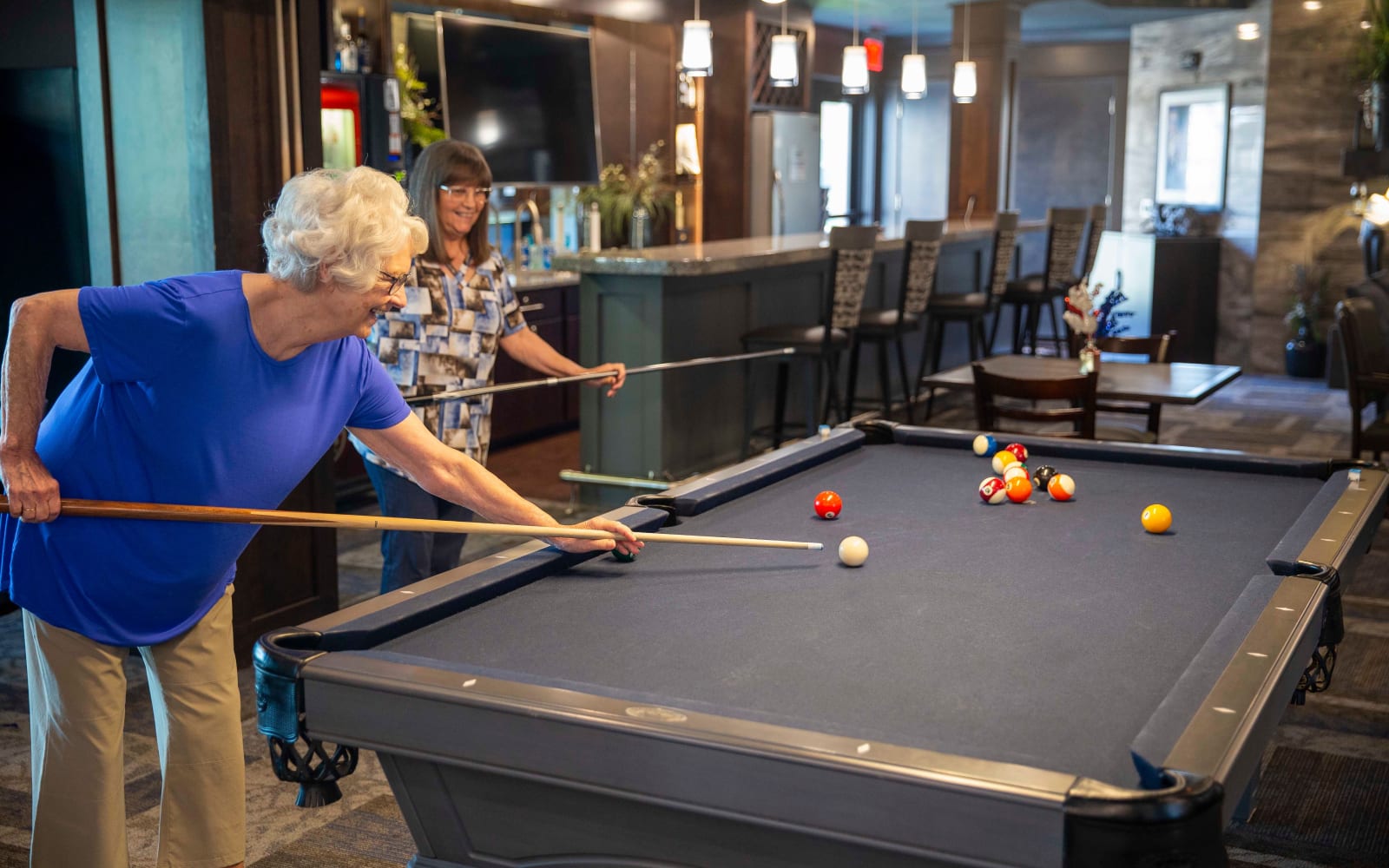 Residents playing pool in the clubhouse at Attivo Trail in Waukee, Iowa