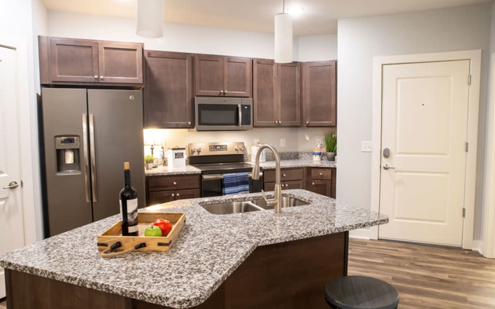 A kitchen located next to the front door in an apartment at Attivo Trail in Waukee, Iowa