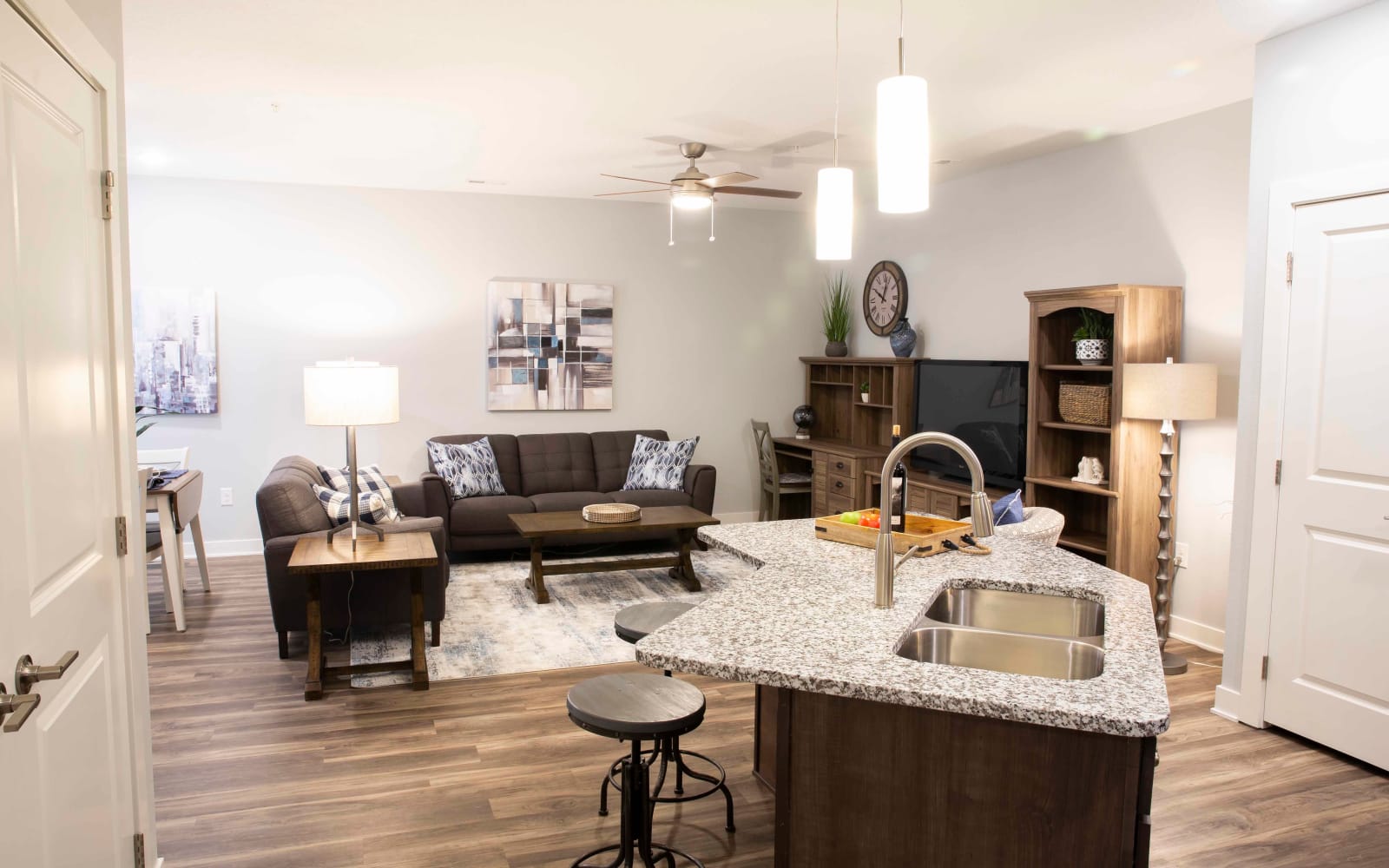 A living room and open kitchen with wood flooring at Attivo Trail Waukee in Waukee, Iowa
