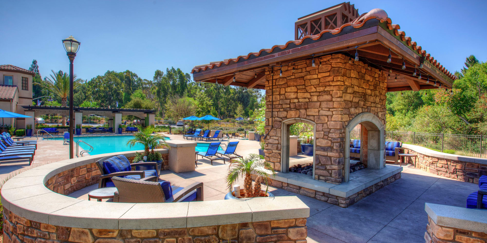 Beautiful view of pool area with fire-pit lounge and lush landscaping in Corona, CA