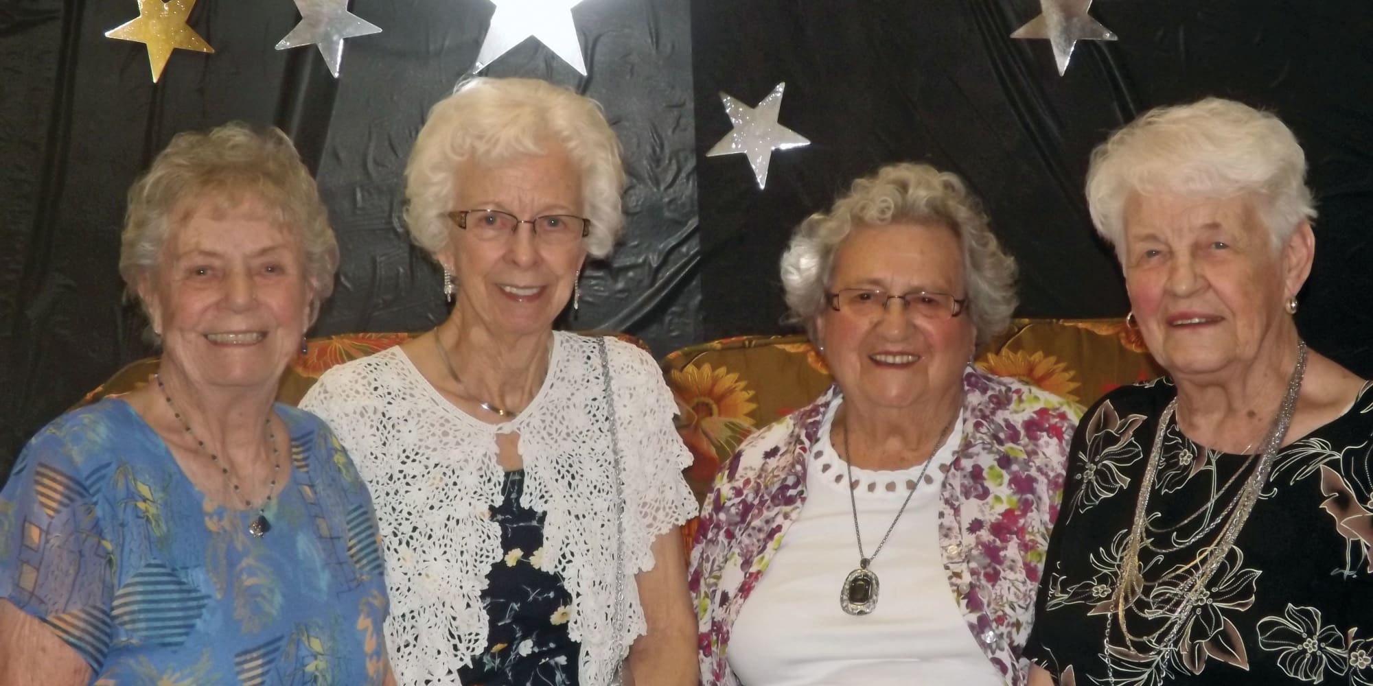Residents posing in front of a backdrop at Williams Place Gracious Retirement Living in Davidson, North Carolina
