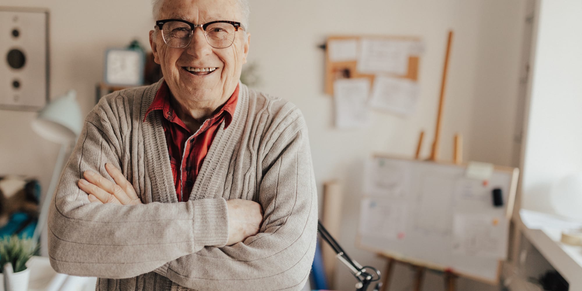 Gentleman wearing glasses in apartment with arms crossed