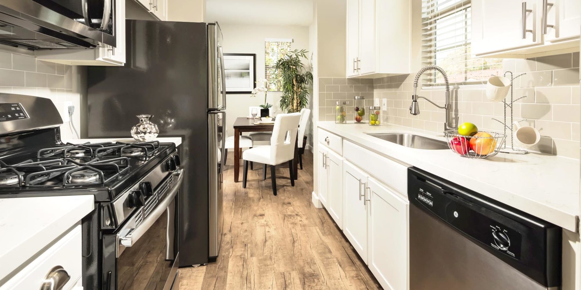 Bright white cabinetry and hardwood flooring in a model home's kitchen at Mission Hills in Camarillo, California