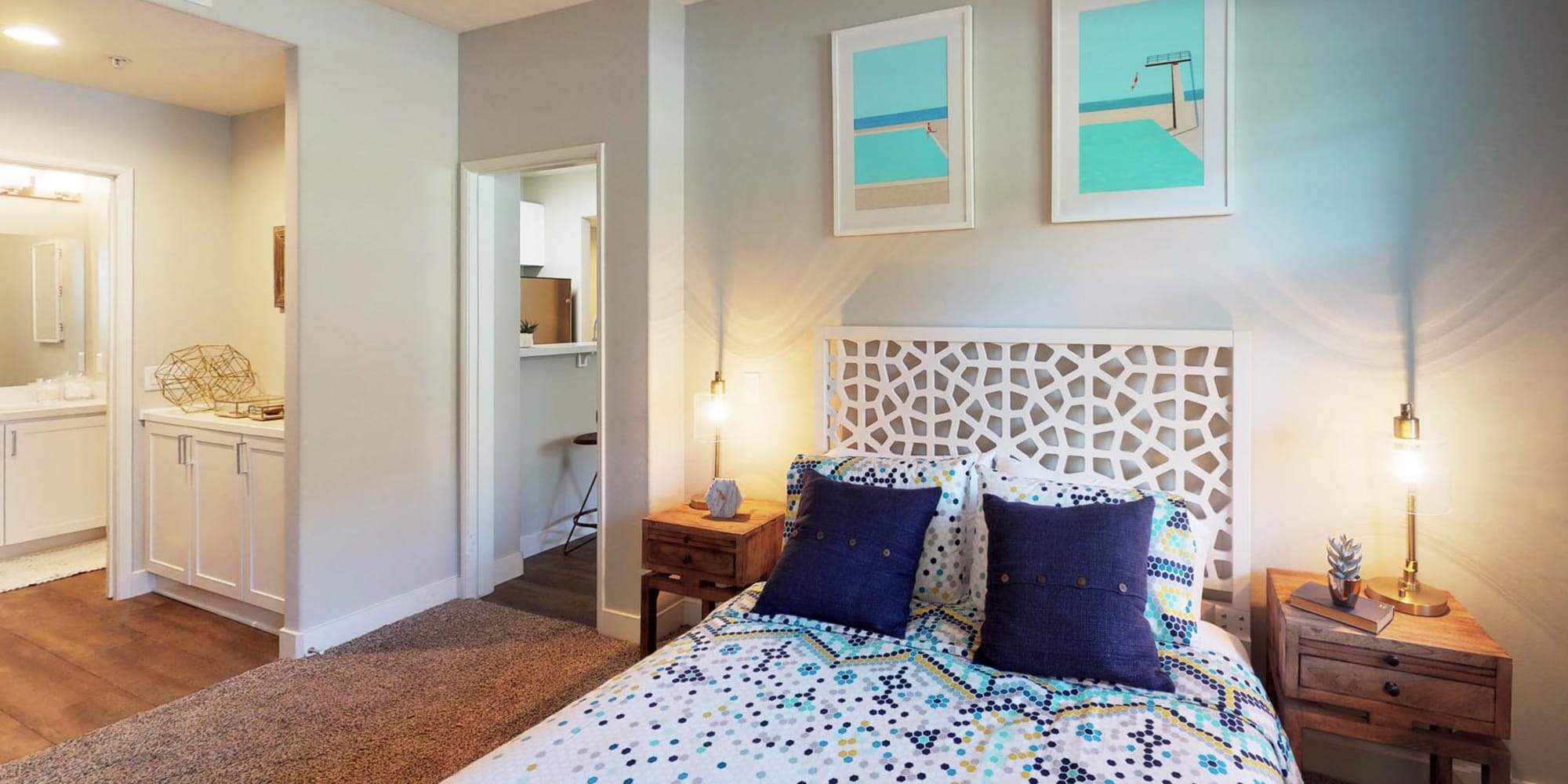 Comfortably furnished primary bedroom with an en suite bathroom in a model home at Mission Hills in Camarillo, California