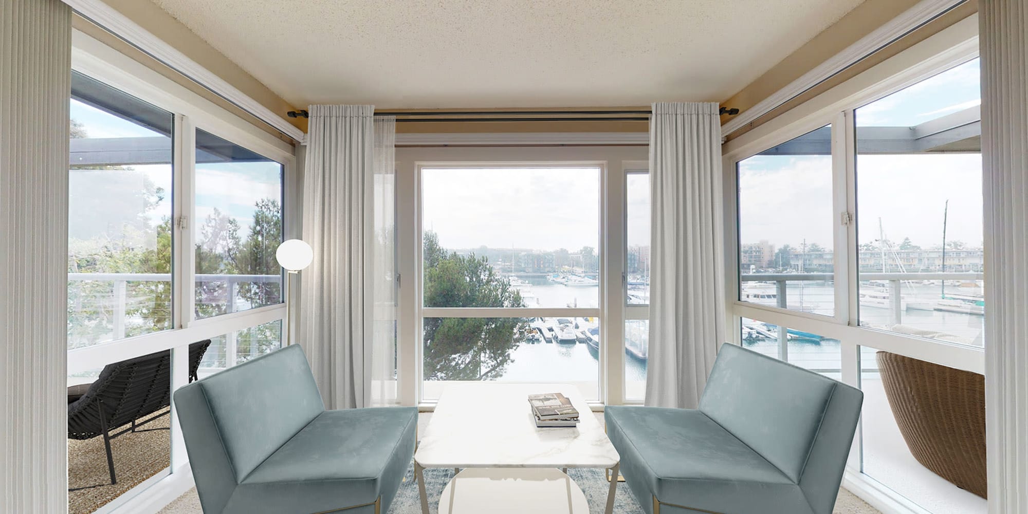 Stylish seating area with expansive waterfront view in a spacouis apartment home at The Tides at Marina Harbor in Marina del Rey, California