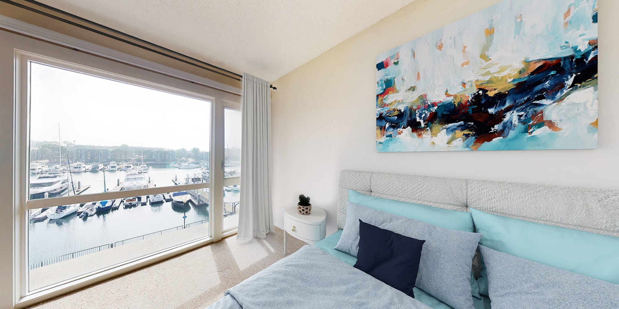 Spacious bedroom with waterfront views of the marina at The Tides at Marina Harbor in Marina del Rey, California