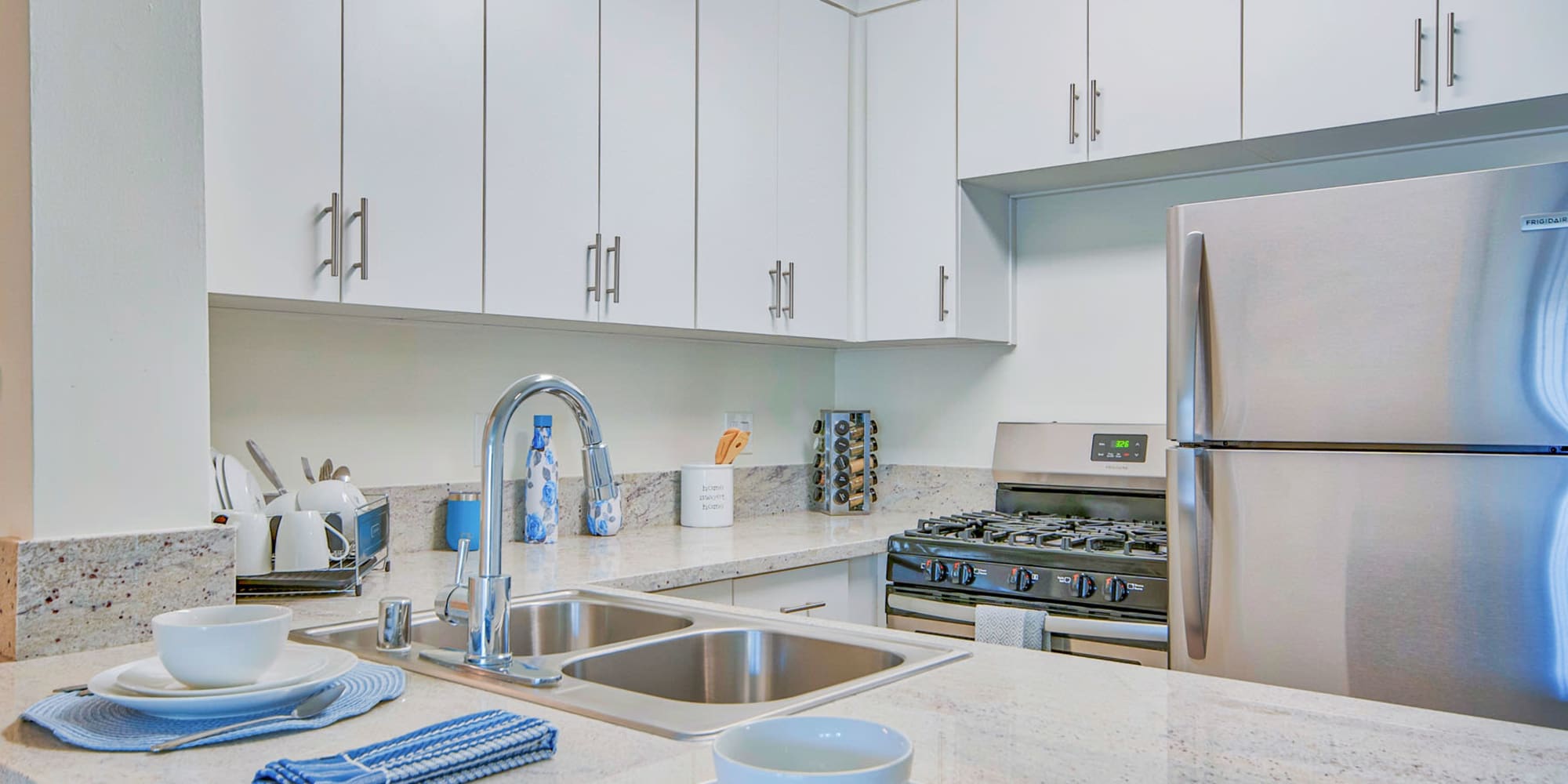 Granite countertops and a dual-basin sink in a model home's kitchen at Villa Vicente in Los Angeles, California