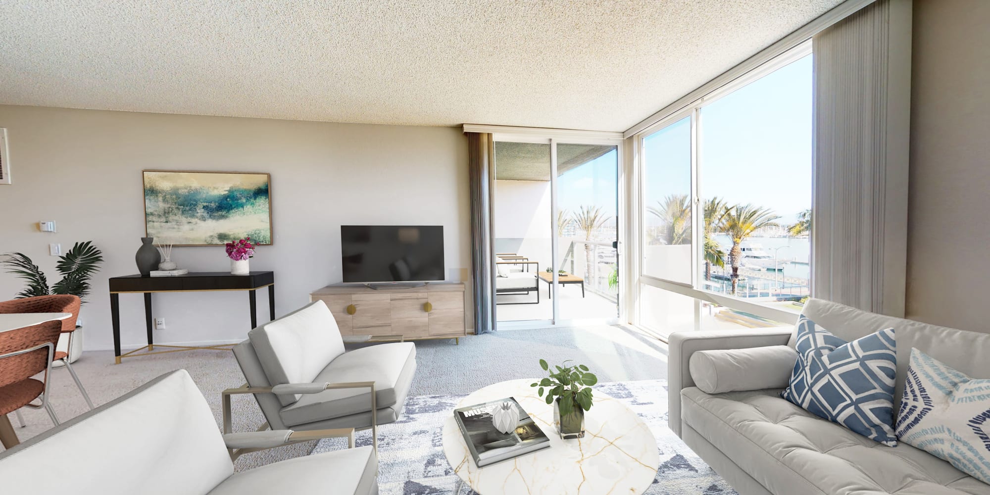 Living room with floor-to-ceiling windows and balcony with views of the marina at Waters Edge at Marina Harbor in Marina del Rey, California