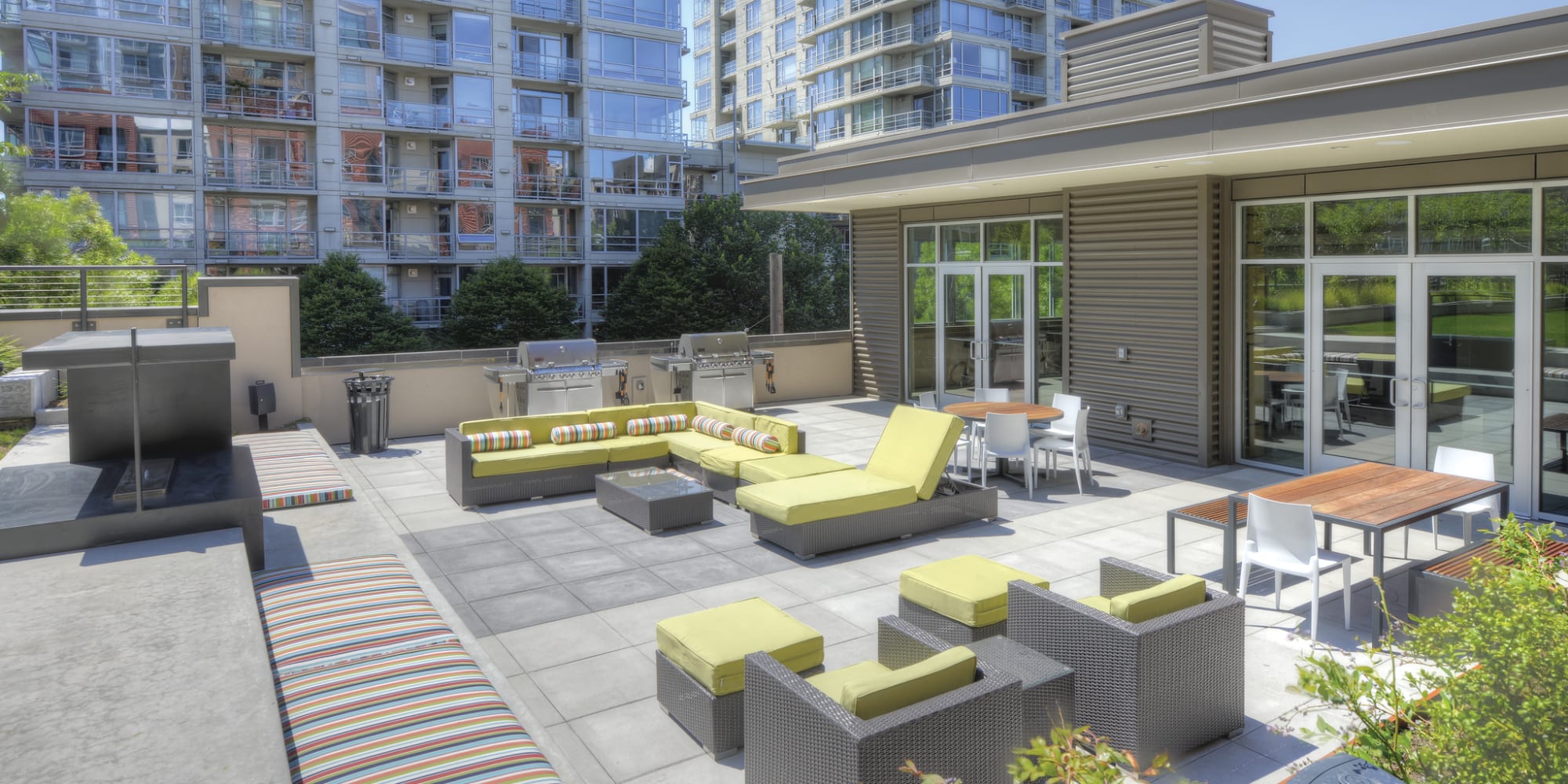 Resident clubhouse sun deck with modern outdoor furnishings and city views at 2900 on First Apartments in Seattle, Washington