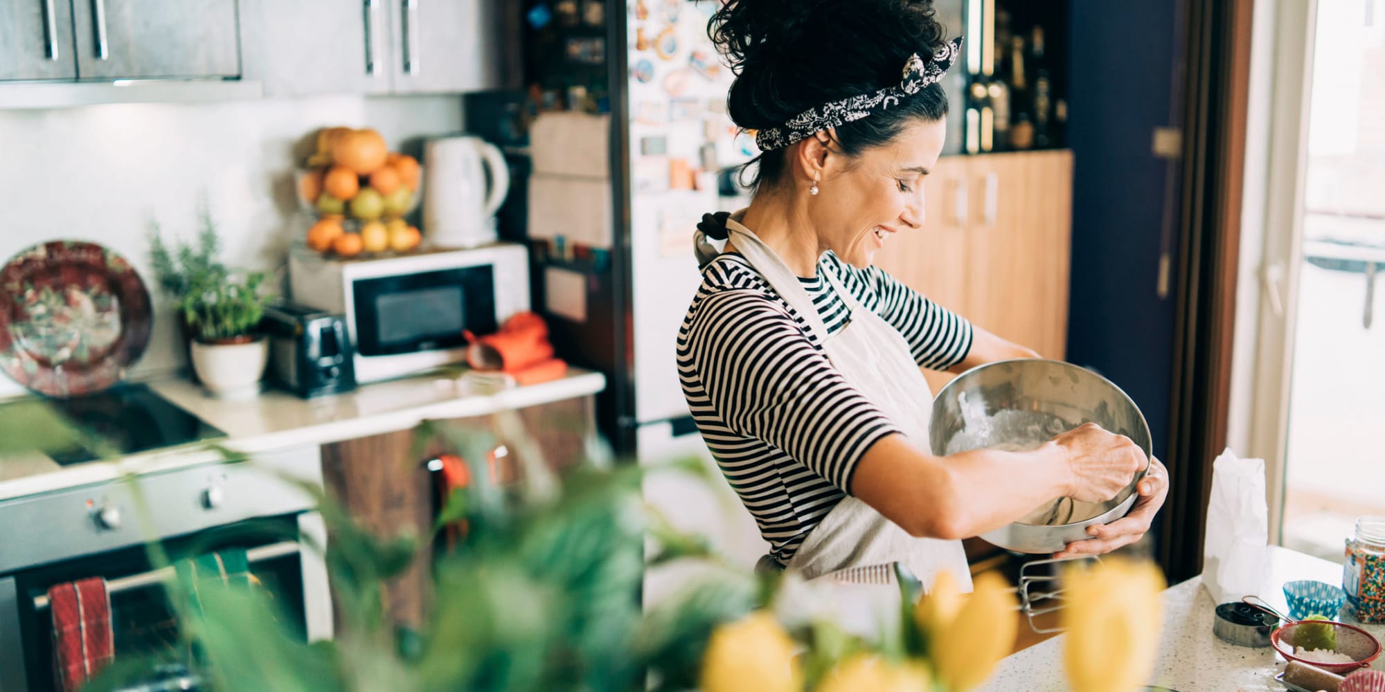 Woman cooking a meal in her home at Portico in Fullerton, California