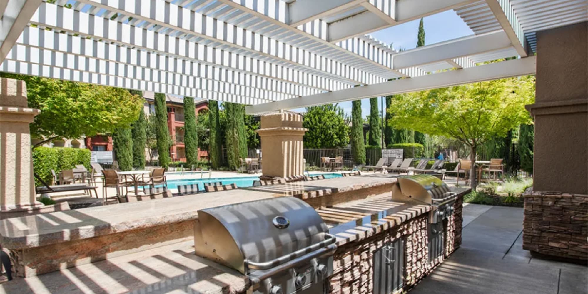 Gas grill and outdoor kitchen under a pergola in the courtyard at Villagio Luxury Apartments in Sacramento, California