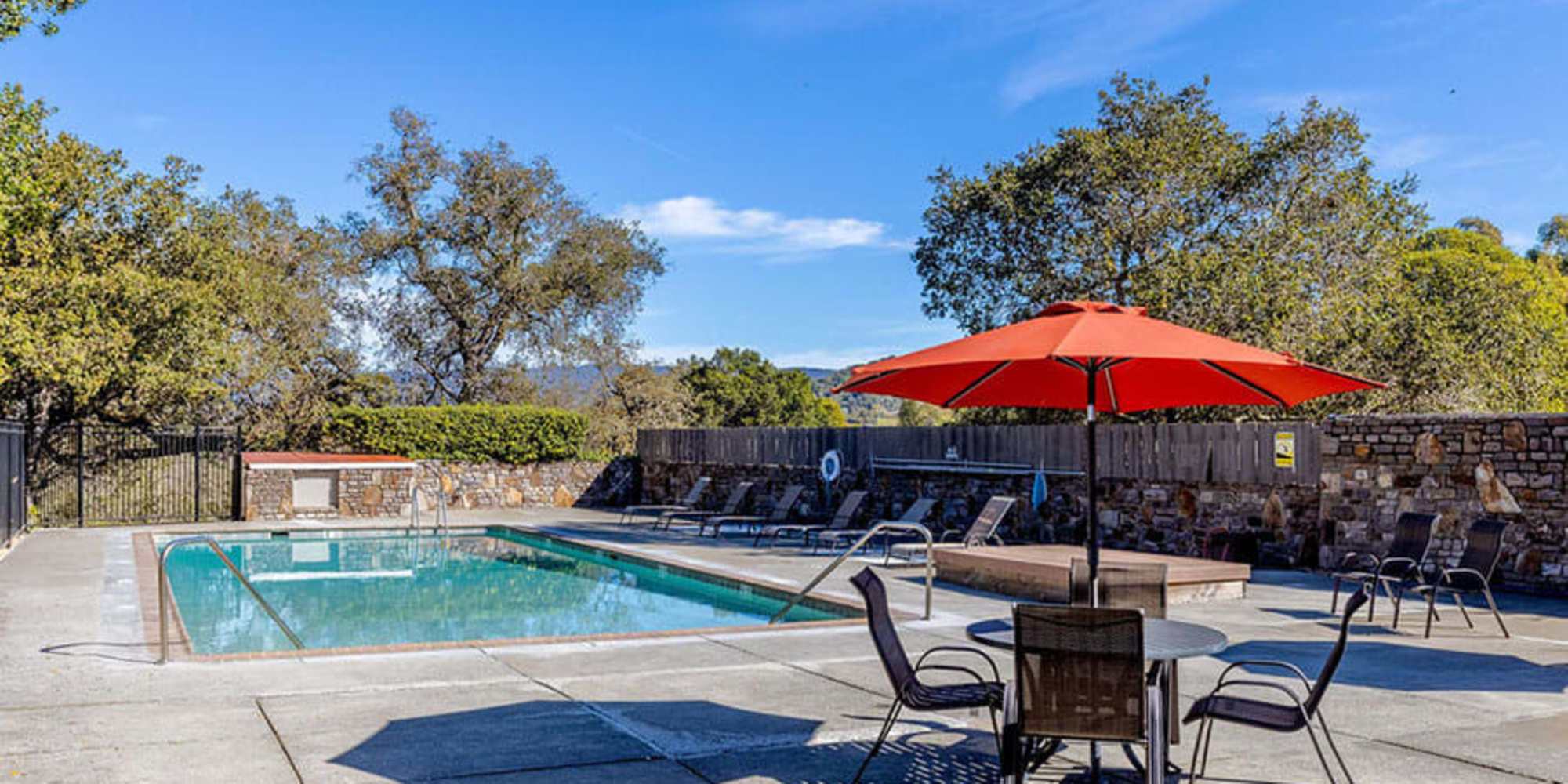 A table with an umbrella and chairs near the swimming pool at Silverado Gardens in Napa, California
