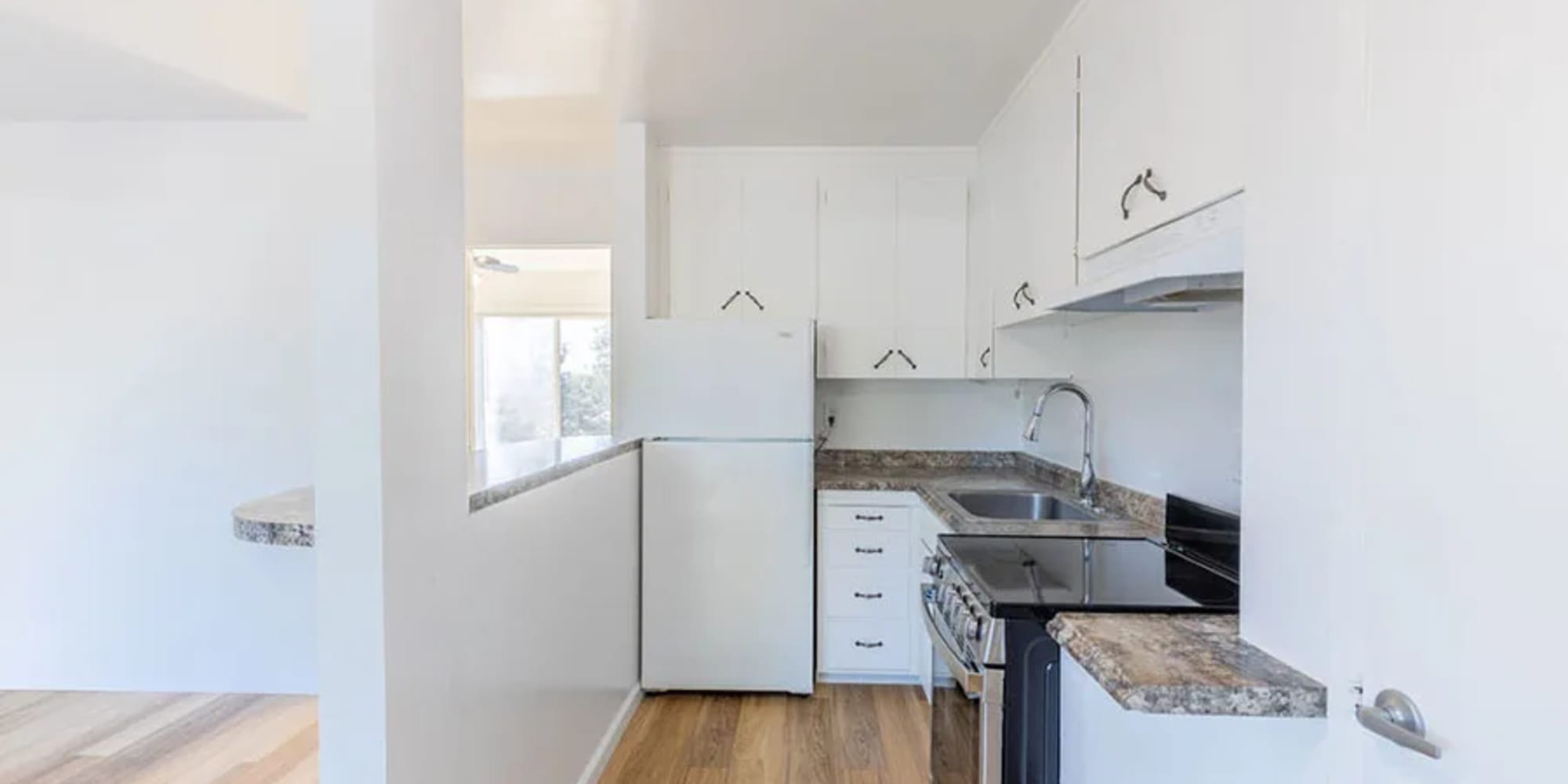 An apartment kitchen with a half-wall divider at Silverado Gardens in Napa, California