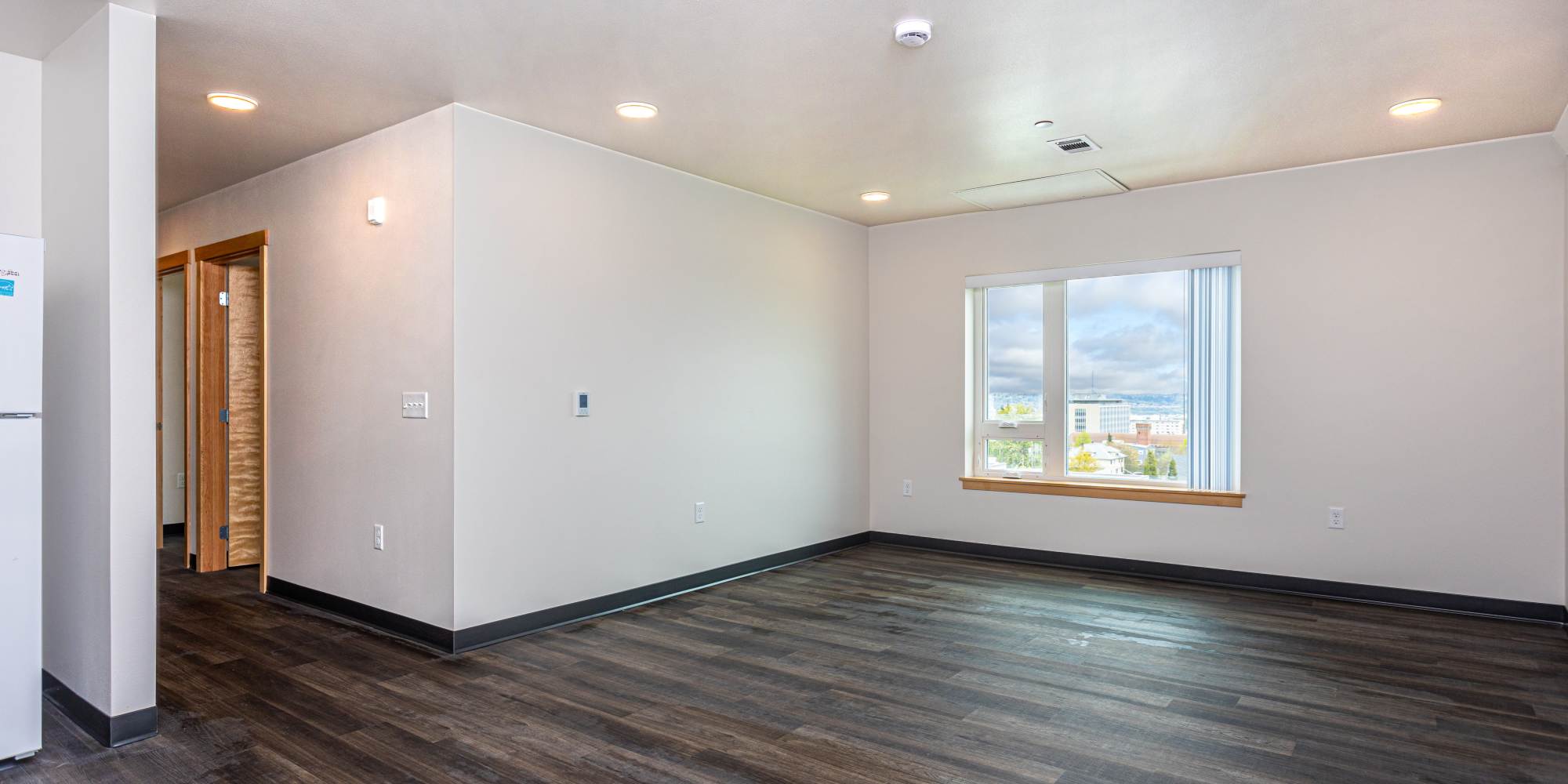 View of the living room with windows at Housing Hilltop in Tacoma, Washington