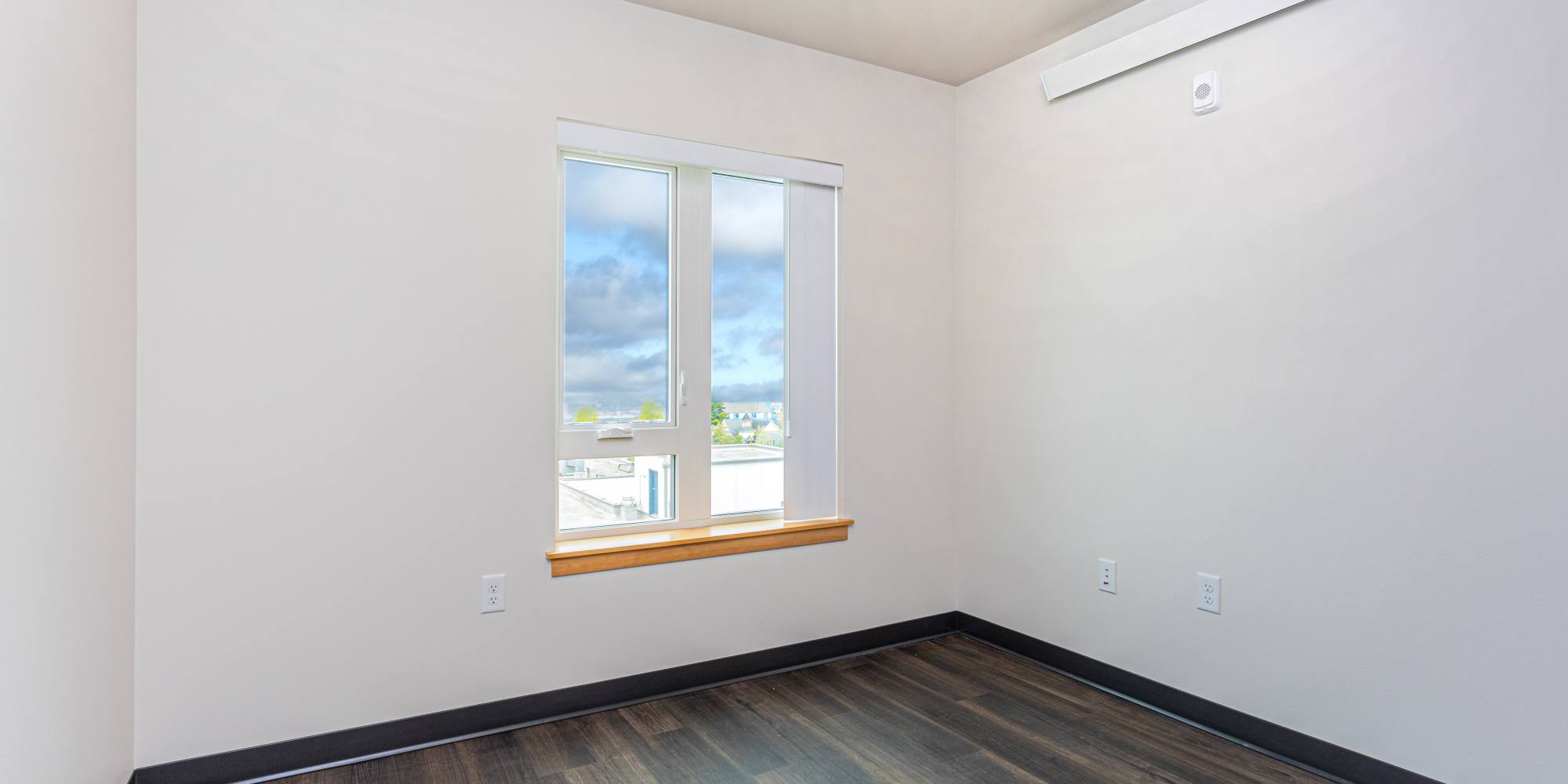 Bedroom with large windows at Housing Hilltop in Tacoma, Washington