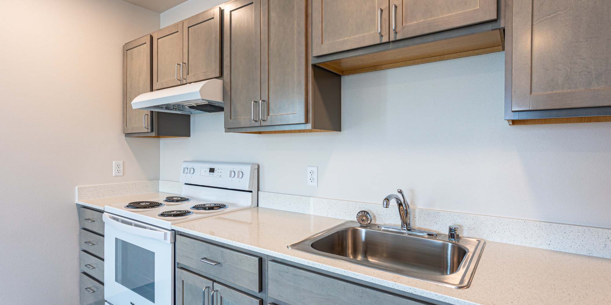Kitchen with wooden cabinets at Housing Hilltop in Tacoma, Washington