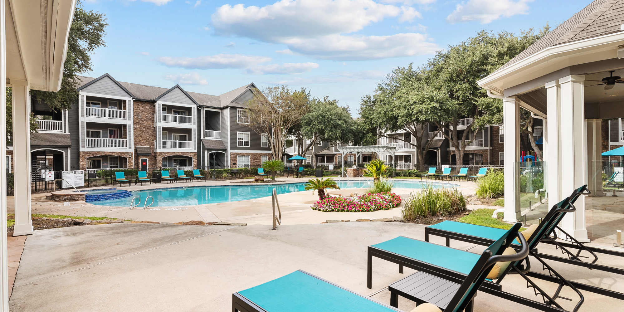 Lounge chairs by the swimming pool at Weston at Copperfield in Houston, Texas