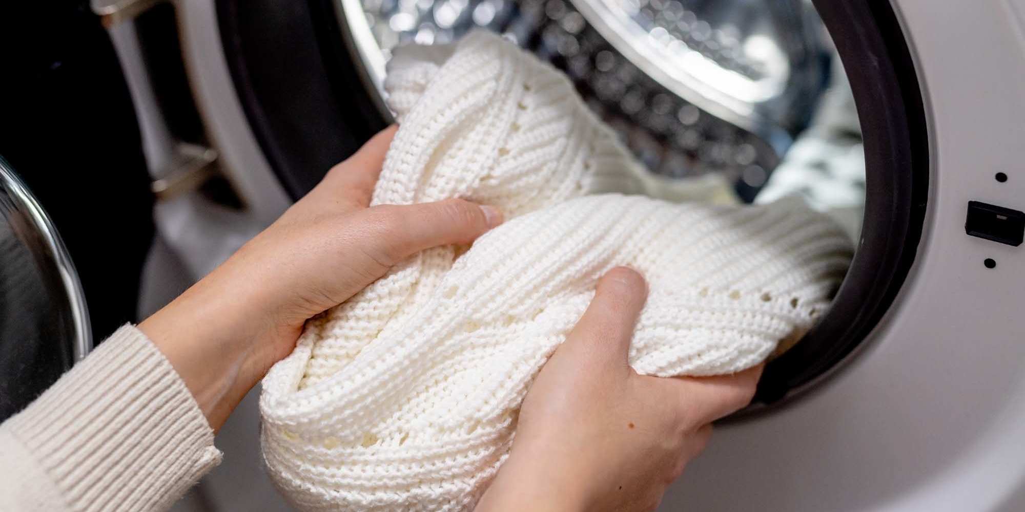 A resident removing a sweater from their dryer at Copper Steppe in Parker, Colorado