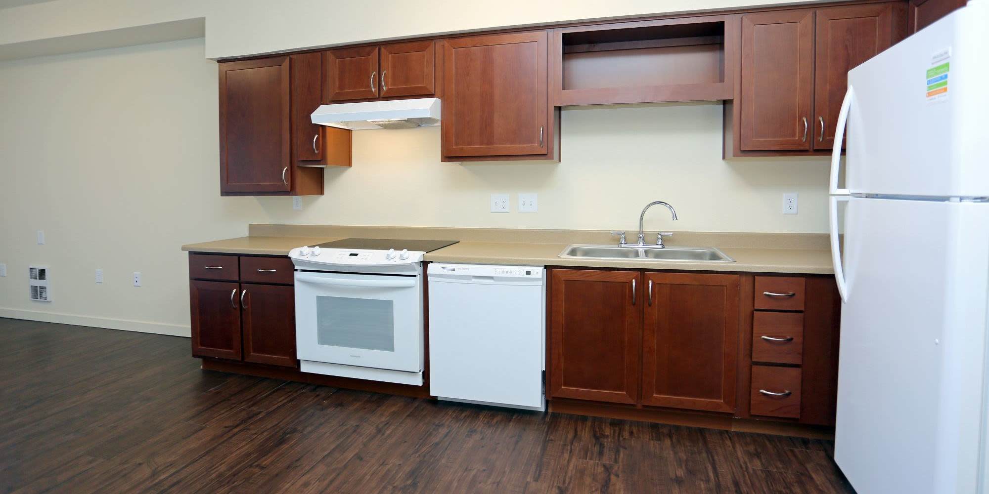 Kitchen with brown cabinets at Traditions at Colorado Springs in Colorado Springs, Colorado