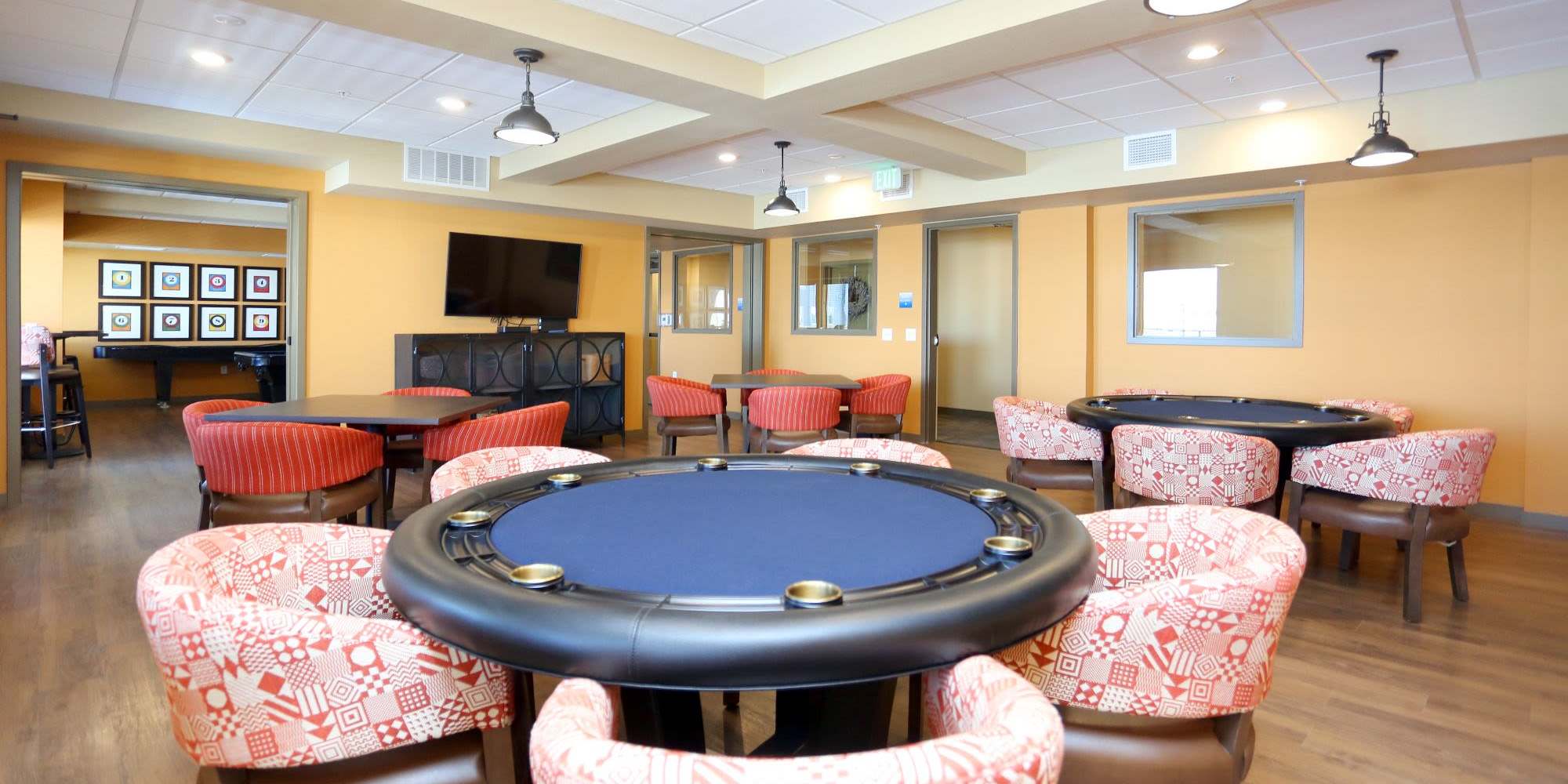 Upscale resident lounge with large chairs, bar seating and a flat screen TV at Traditions at Colorado Springs in Colorado Springs, Colorado