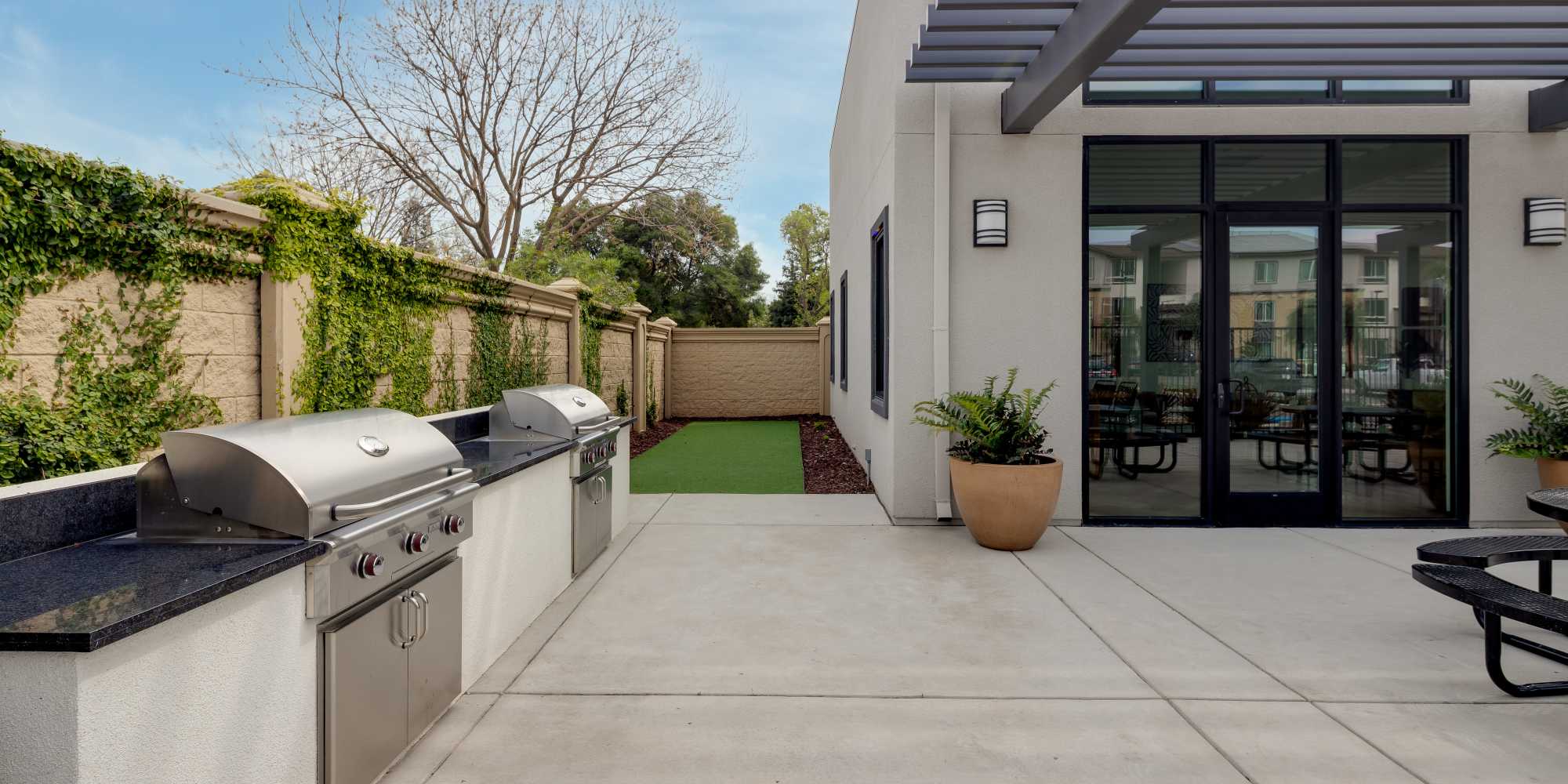 Outdoor patio area with grills at Village at First in Gilroy, California
