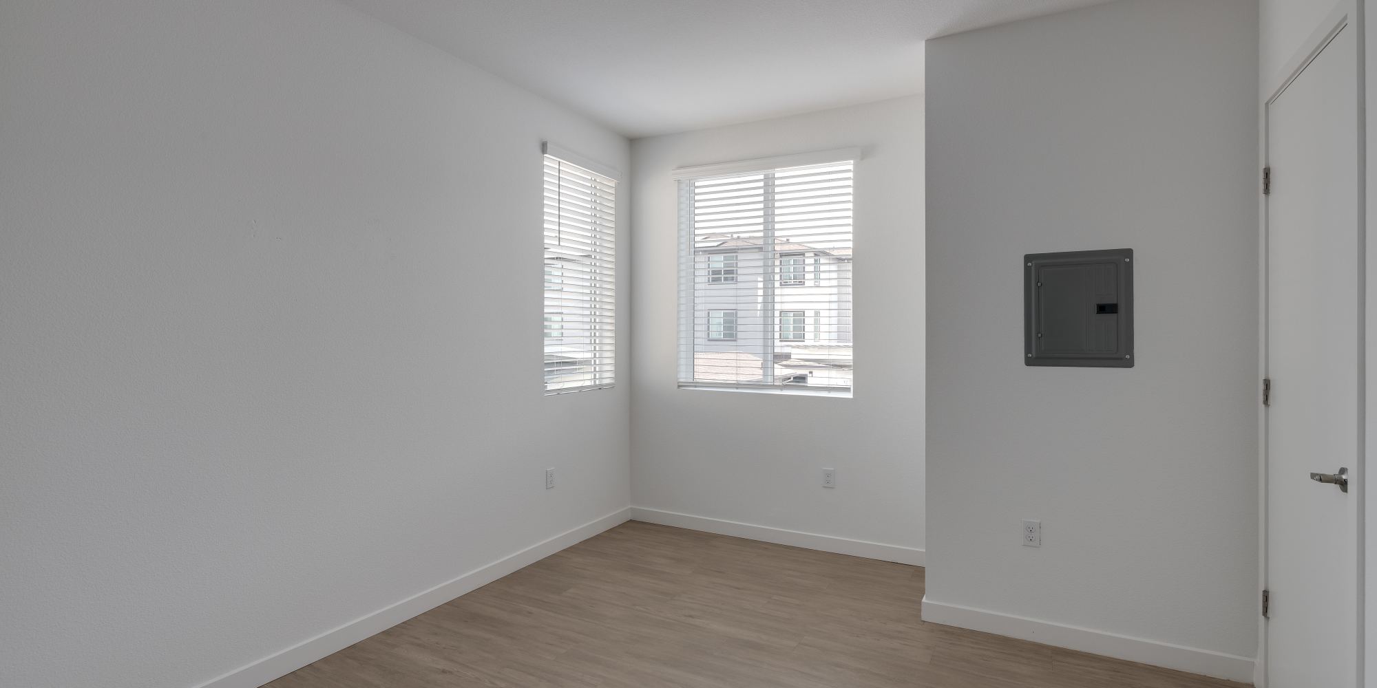 Bedroom with wood-style flooring at Village at First in Gilroy, California