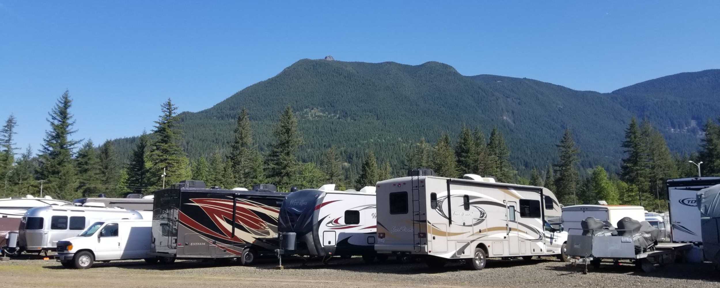 A storage facility parking lot featuring a variety of RVs parked closely together at Ole Cedar Mill Mini Storage, North Bend, Washington