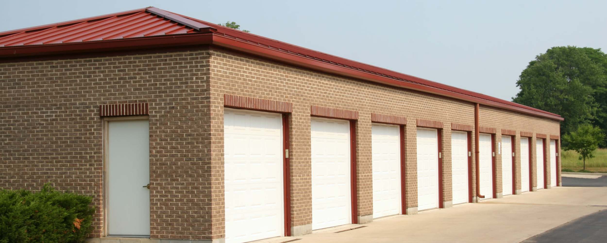 Garage doors with brick wall and red roof at Centennial Storage in Bonney Lake, Washington