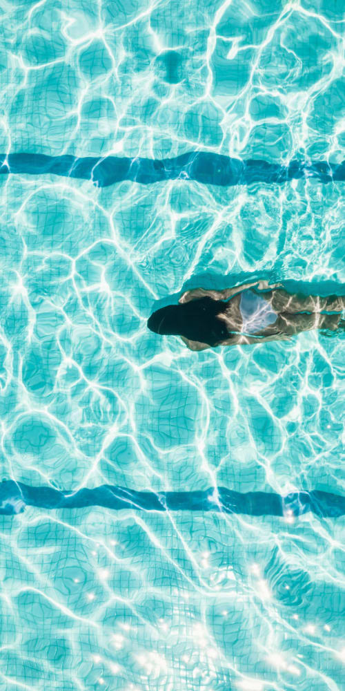 Resident swiming in the pool at Glen Lakes Rental Homes in Weeki Wachee, Florida
