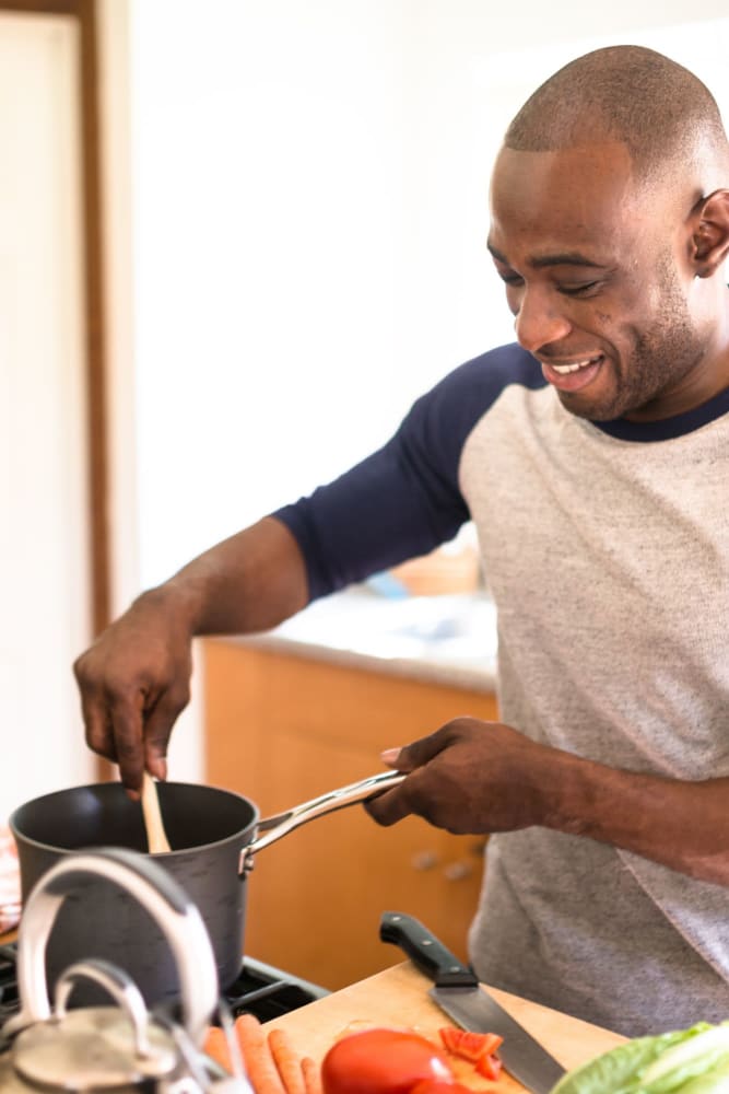 Resident cooking a meal in his kitchen at Audubon Village in Bridge City, Louisiana