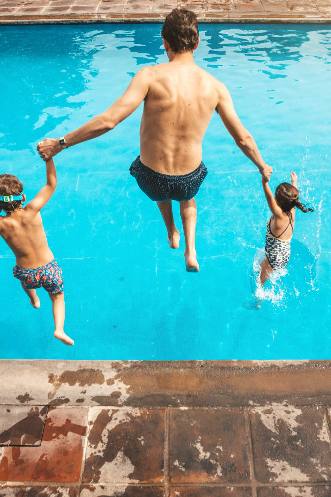 Father and children jumping into the pool at Brightside at Jefferson in Jefferson, Georgia