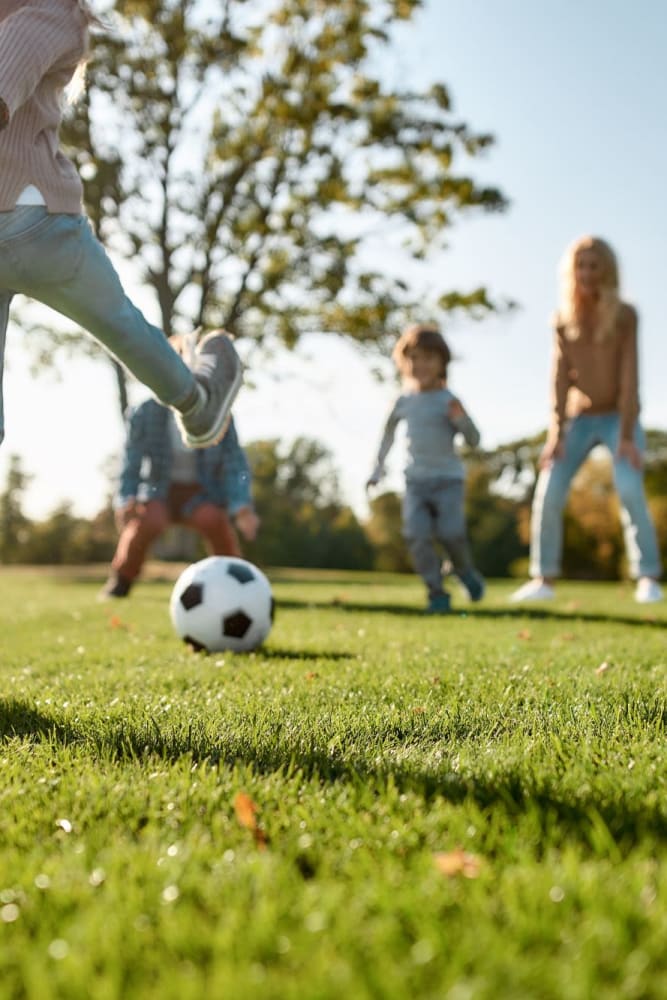 Resident playing soccer with his kids at park near Creekside Gardens in Vacaville, California