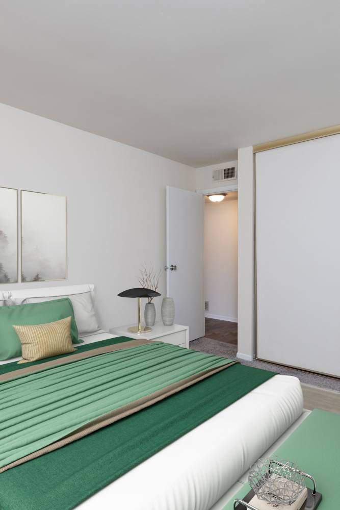 Staged bedroom with wall to wall carpeting at Squires Manor Apartment Homes in South Park, Pennsylvania