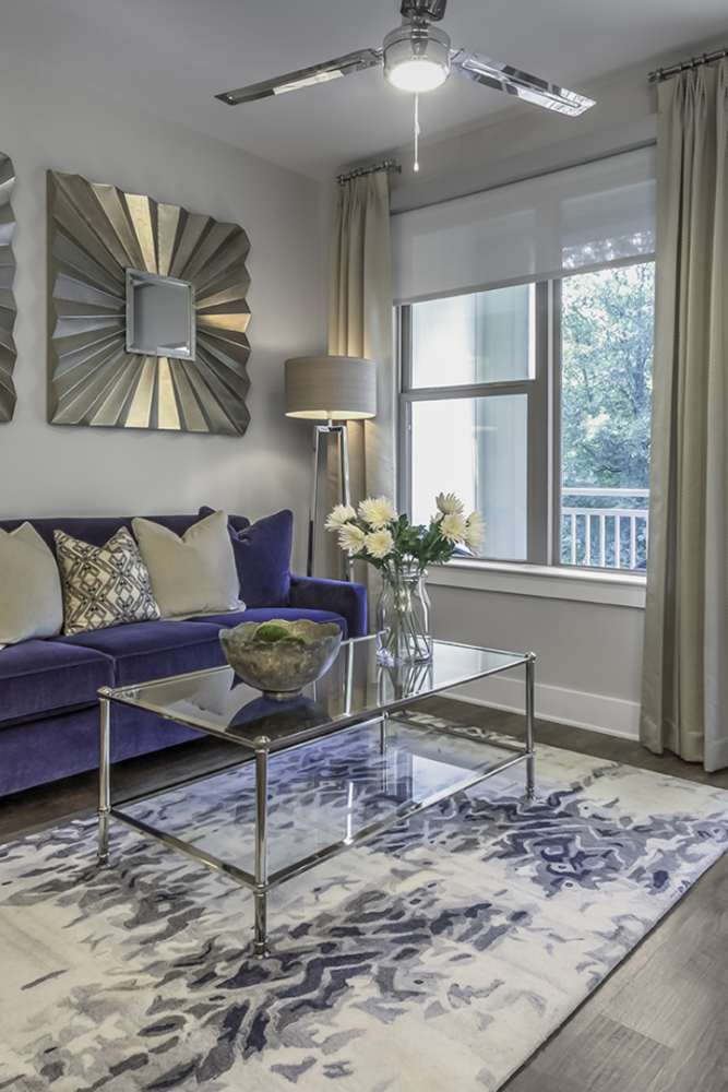 Luxury living room with a comfortable couch, and a door leading to the private balcony at Greenside in Charlotte, North Carolina