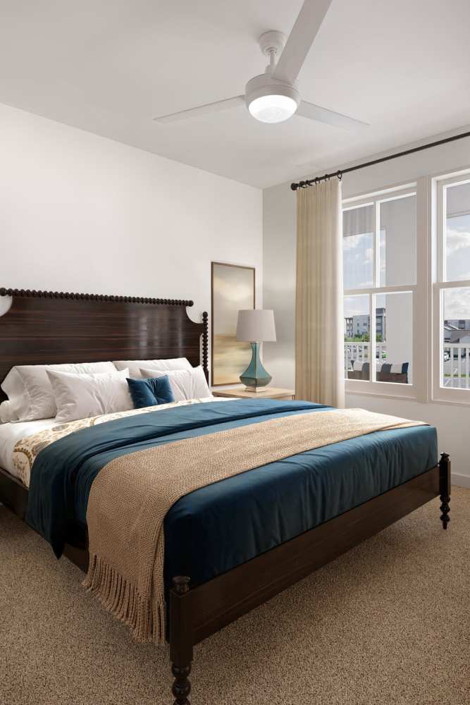 Cozy bedroom with large windows at Romero Apartments in Pensacola, Florida